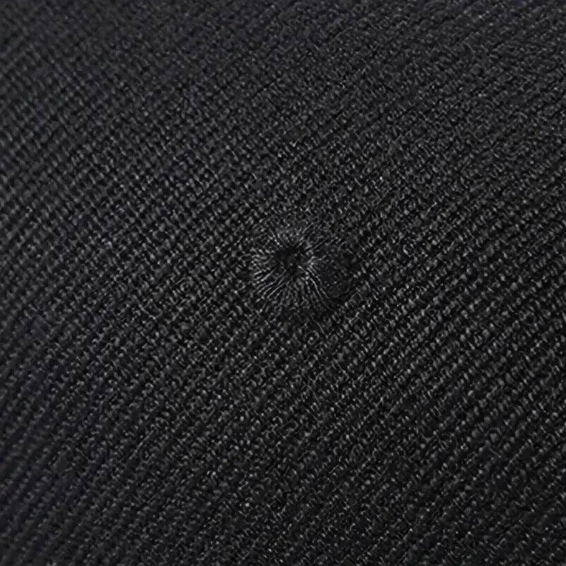 Black textured fabric with woven pattern and central buttonhole detail