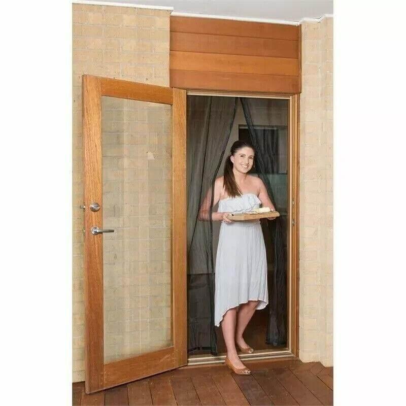 Woman holding tray in doorway with wooden door and curtain backdrop