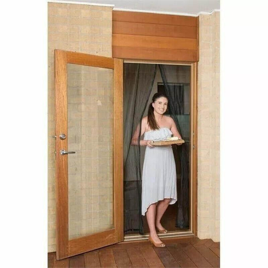 Woman holding tray in doorway with wooden door and curtain backdrop