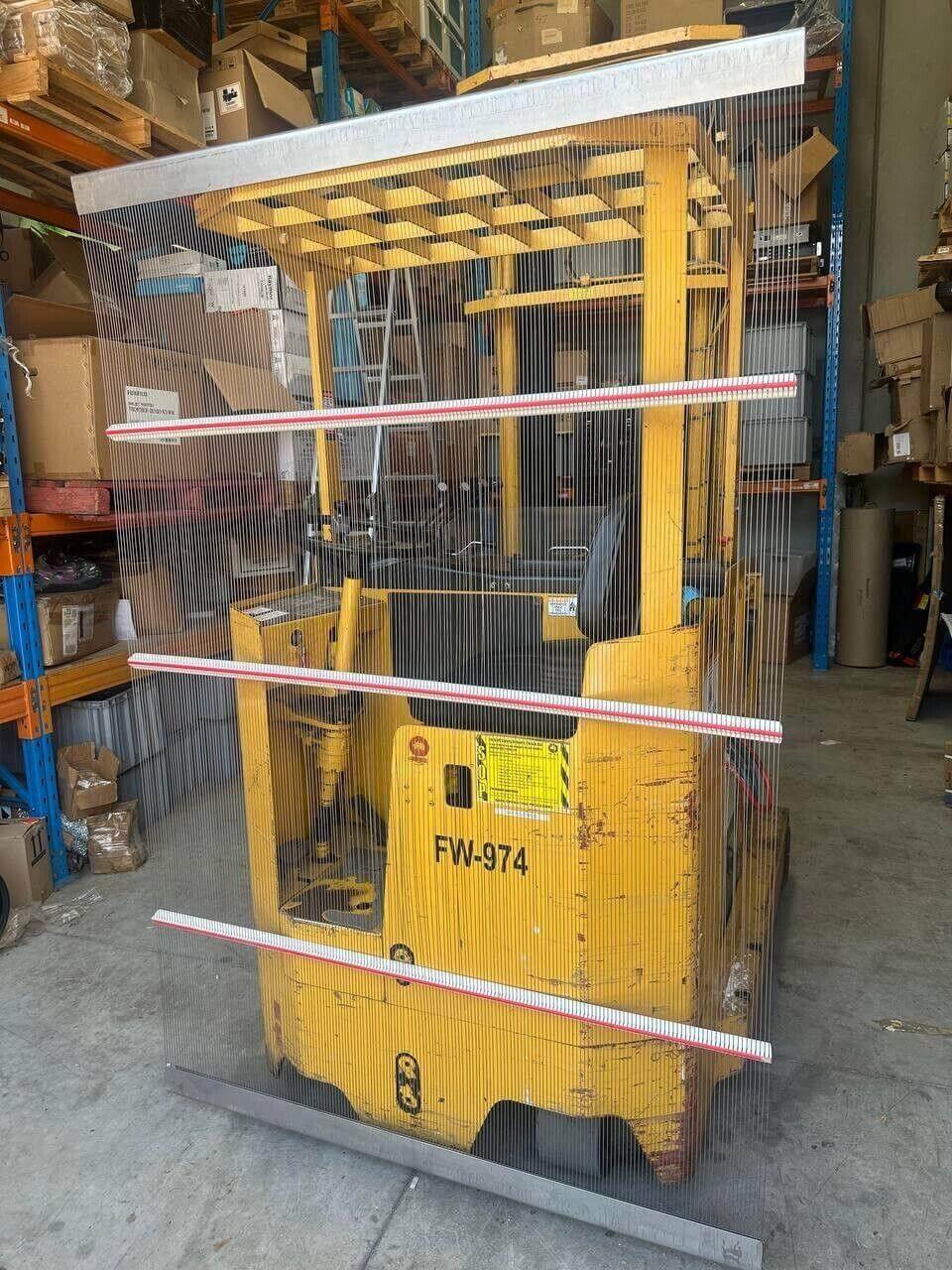 Yellow forklift FW-974 behind safety string barrier in warehouse with shelving and boxes