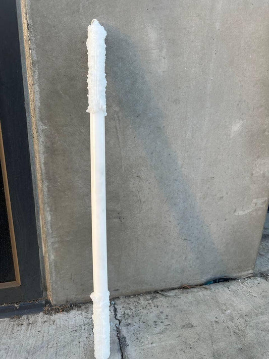 White textured plastic pole leaning against concrete wall