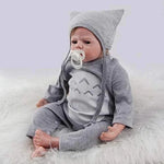 Realistic baby doll in gray Totoro outfit with pacifier, soft fur background