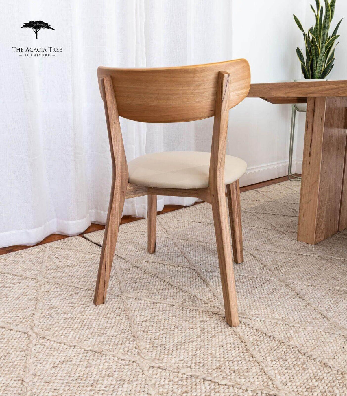 Wooden dining chair with beige cushion, modern design, paired with matching table and rug