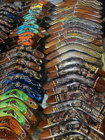 Colorful hand-painted boomerangs with Aboriginal art designs, showcasing cultural patterns and vibrant hues.