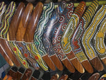 Colorful Aboriginal boomerangs with dot art designs, wooden handles, and vibrant patterns