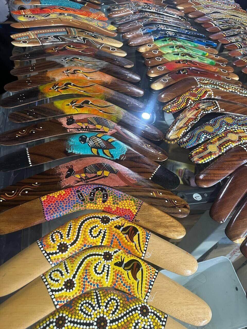 Colorful hand-painted Australian boomerangs with Aboriginal dot art designs, displayed in rows