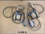 Blue and silver office phone handsets with coiled cords on beige surface