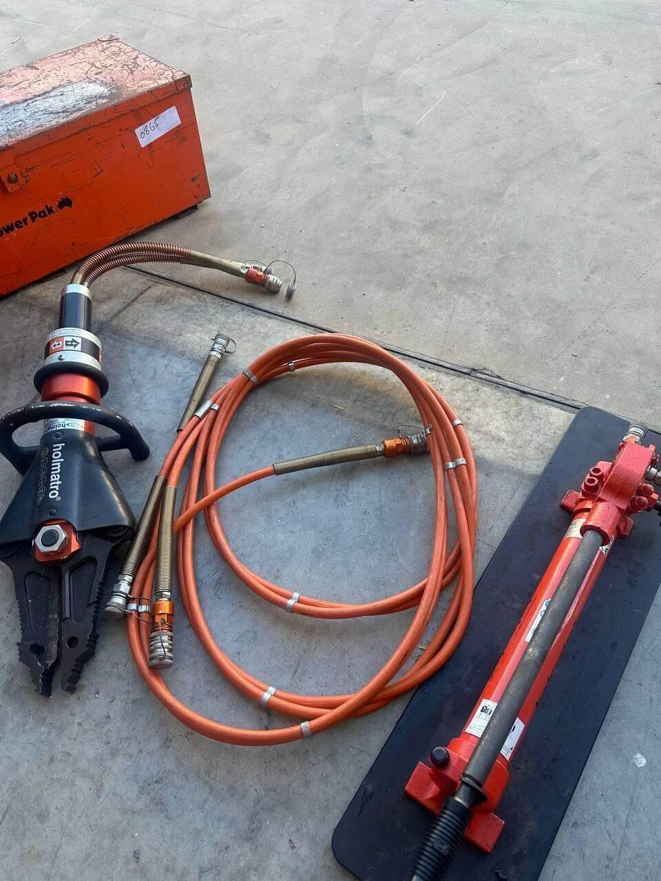 Holmatro hydraulic rescue tools with orange hoses and power pack for emergency vehicle extrication