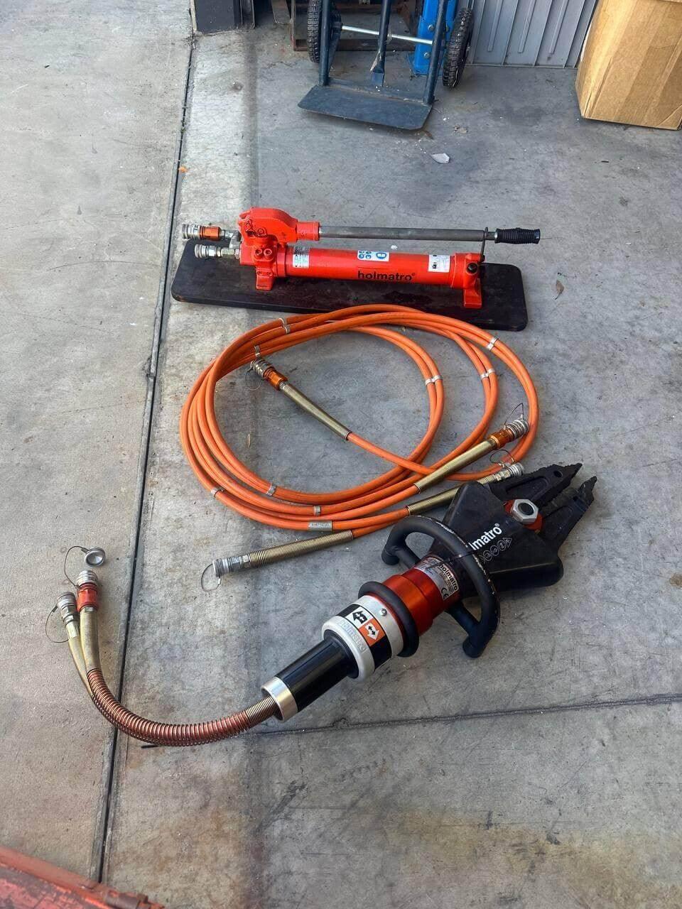 Holmatro hydraulic rescue tools with orange hoses, ideal for auto repair and emergency services