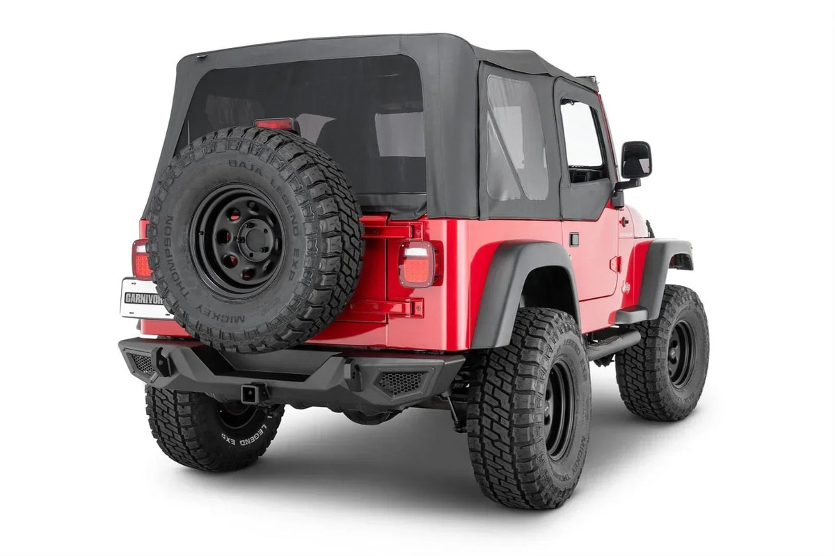 Red Jeep Wrangler with black soft top, off-road tires, and rear spare tire mount