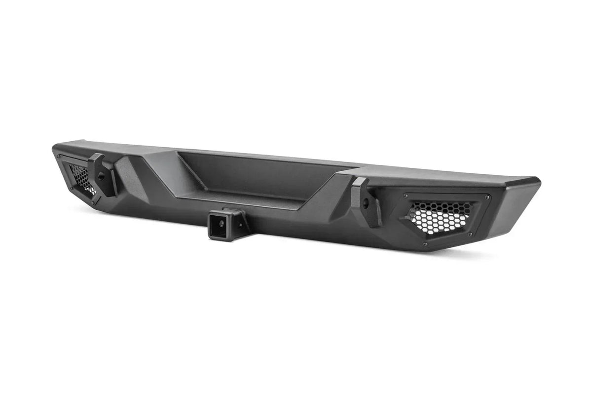 Black heavy-duty truck rear bumper with honeycomb grille and tow hitch for off-road use