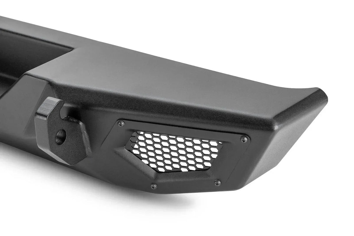 Black heavy-duty truck bumper with honeycomb grille and tow hook, rugged off-road design