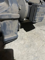 Dusty industrial SEW motor component on concrete floor, ideal for tractor or truck parts
