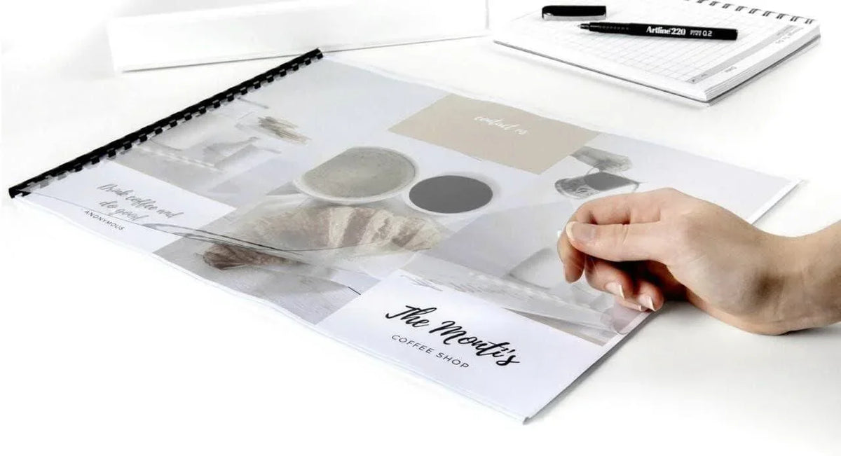 Clear PVC table cover with coffee shop design, protecting menu on white desk