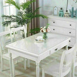 Clear PVC table cover on a dining table, protecting the surface while keeping it visible