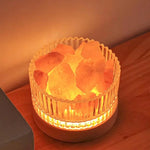 Glowing Himalayan salt lamp in glass holder, warm ambient lighting for home decor