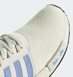 White sneaker with blue stripes and textured fabric, ideal for casual wear or workwear