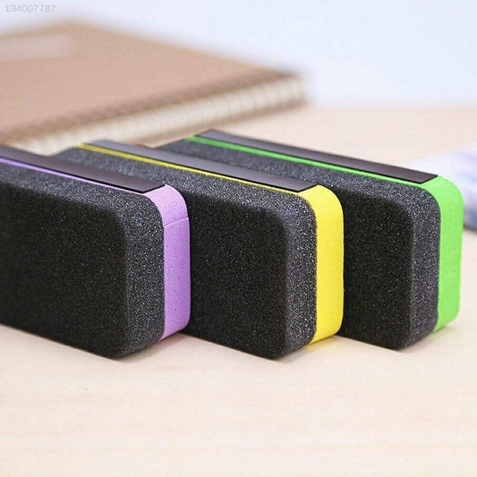 Colorful magnetic whiteboard erasers with foam, placed on a wooden desk