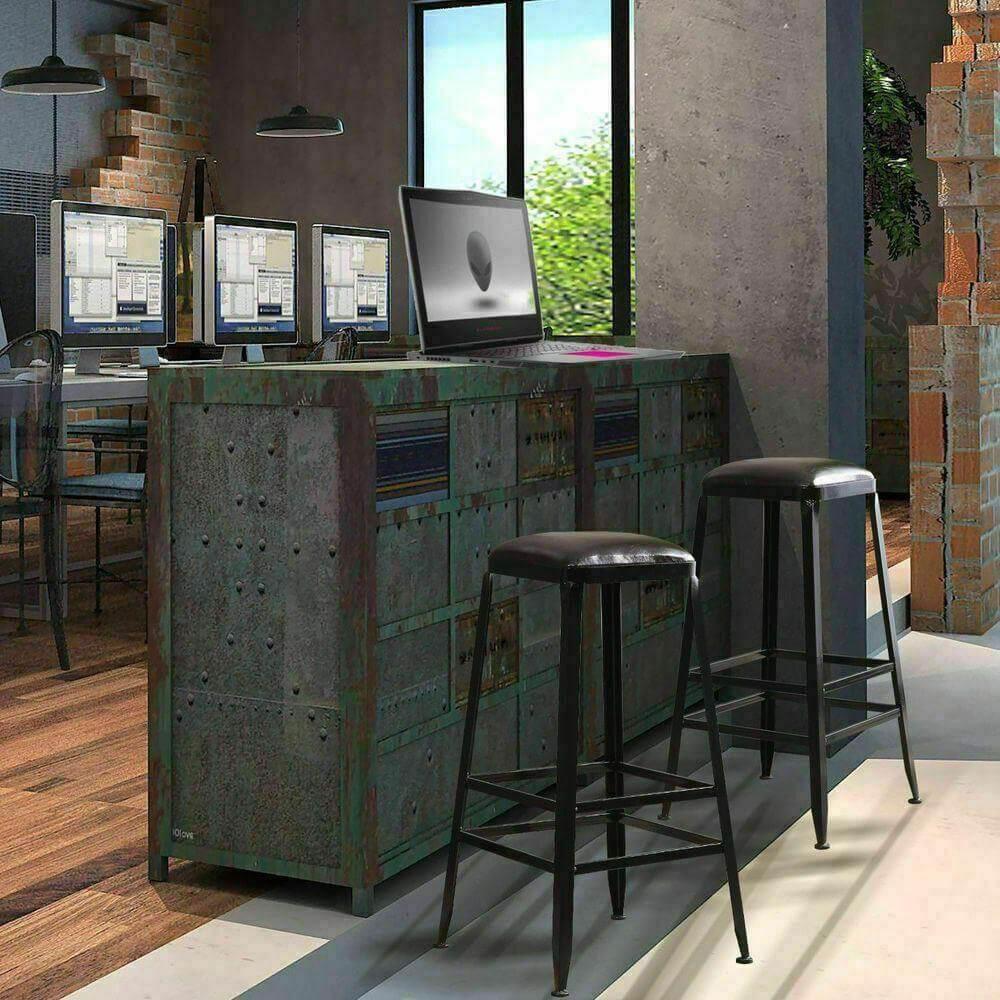 Pair of black industrial bar stools with leather seats at a rustic kitchen counter in loft space