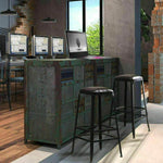 Pair of black industrial bar stools with leather seats at a rustic kitchen counter in loft space