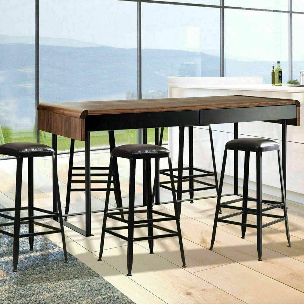 Set of four industrial bar stools with black metal legs and leather seats around a wooden dining table in a modern kitchen