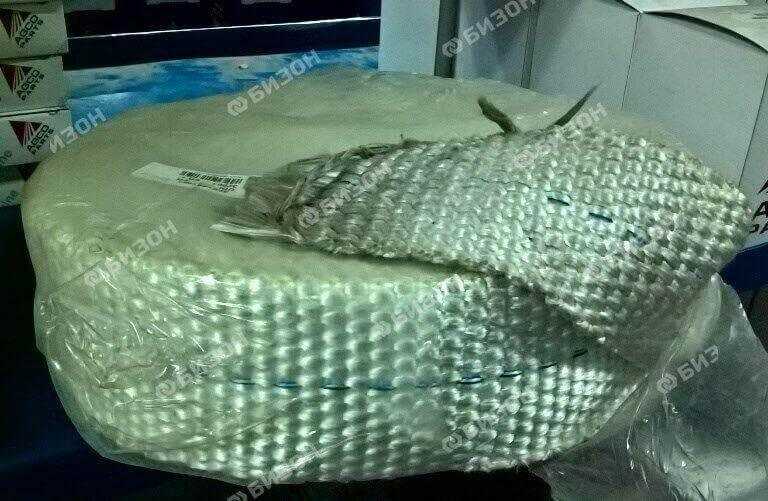Roll of white fiberglass insulation tape for tractor or machinery repair, close-up view