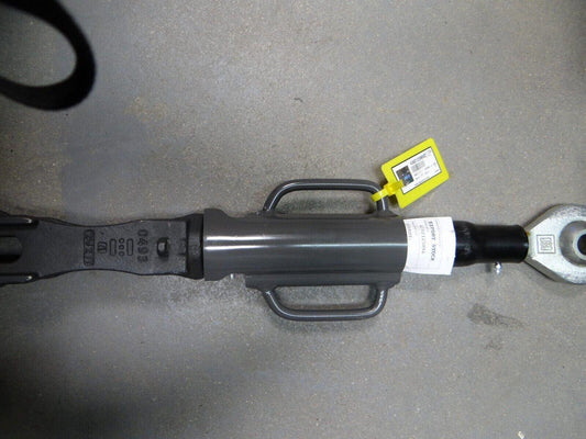 Metal tractor hanger part with handles and label on a concrete surface