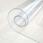 Clear rolled PVC tablecloth protector showcasing durable and waterproof material for table surface protection.