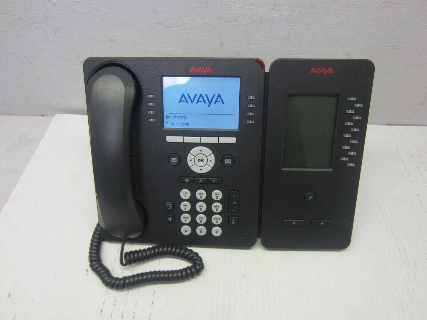 Avaya 9608G IP desk phone with button module, office telephone system on table