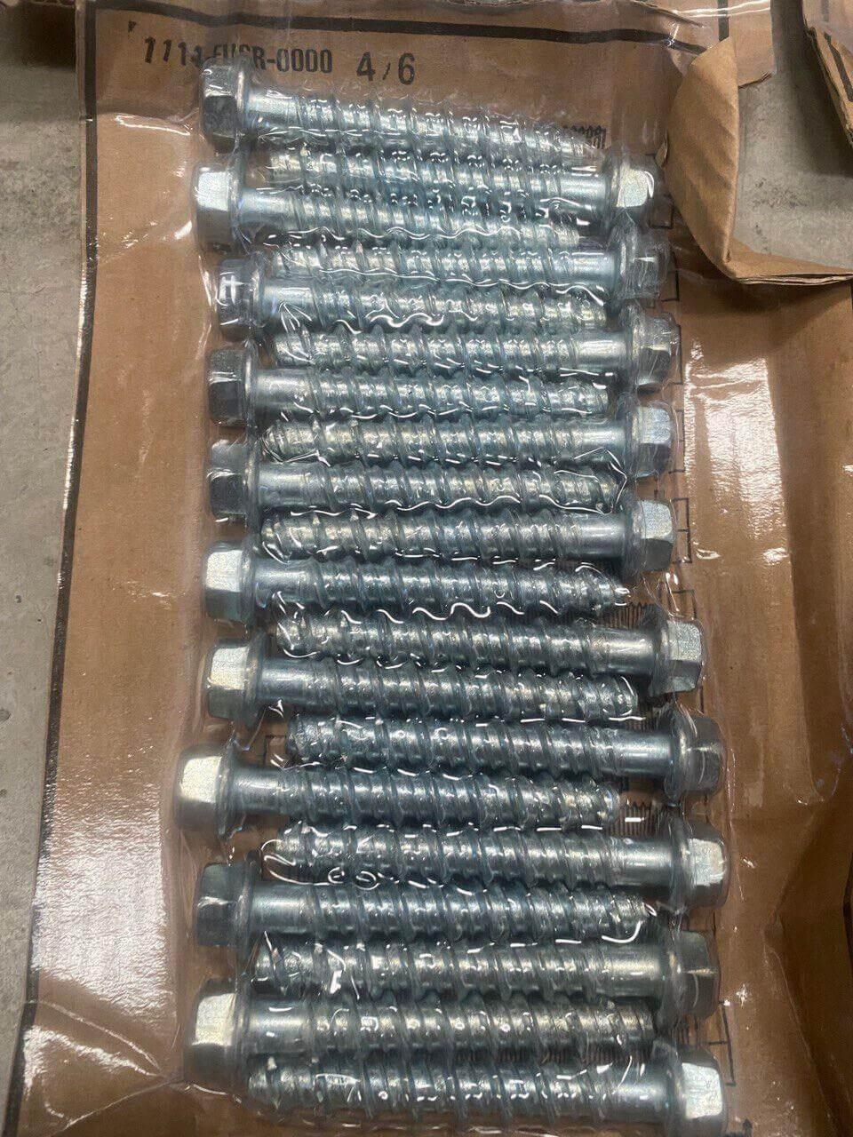 Bulk lot of metal hex head bolts arranged on cardboard in clear packaging.