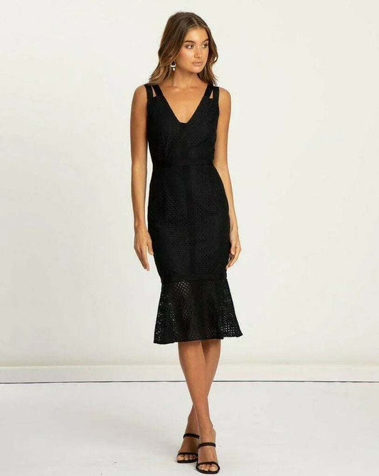 Woman in a black lace midi dress with V-neck and ruffle hem, wearing black heels
