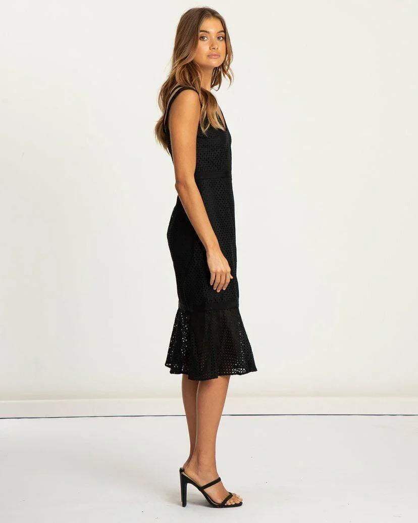 Woman wearing black lace midi dress with sleeveless design and flared hem, formal style