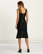 Woman wearing black lace midi dress with double straps and flared hem, viewed from back