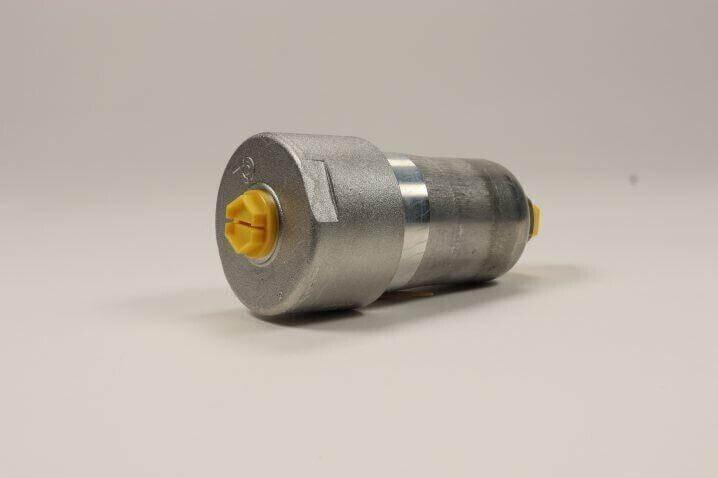 Hydraulic filter for tractor, cylindrical metal part with yellow end caps, on neutral background