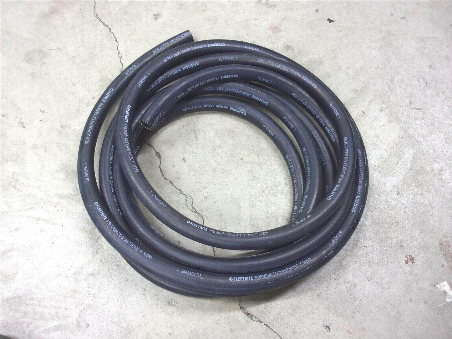 Coiled black Fleetrite heater coolant hose for trucks on concrete floor