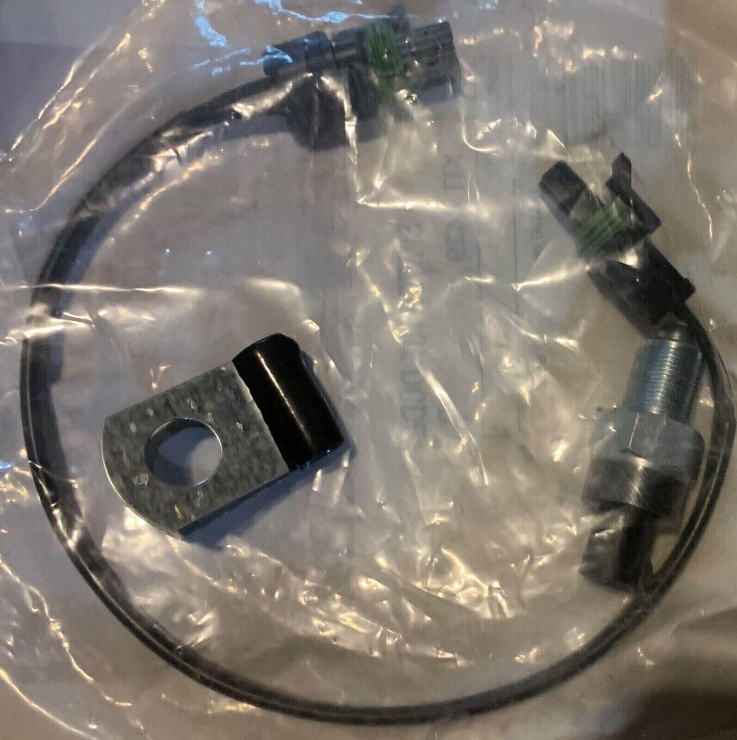 Truck lock switch wiring kit with connector and mounting bracket in plastic packaging