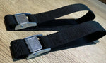 Black heavy-duty tie-down straps with metal buckles on wood surface, ideal for securing cargo or equipment.