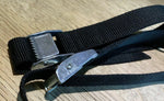 Black nylon cargo strap with metal ratchet buckle for securing loads, ideal for truck parts and equipment transport