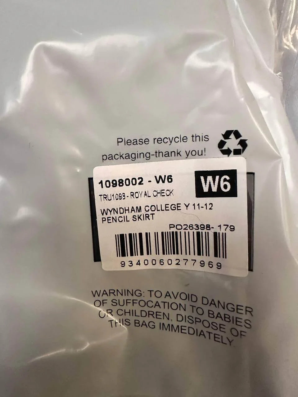 Wyndham College Y11-12 pencil skirt in royal check, packaged with recycling info and safety warning label.