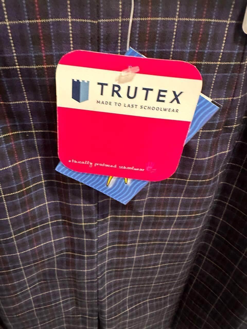 Trutex schoolwear tag on plaid uniform pants, ethically produced durable school clothing