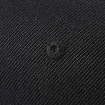 Black textured fabric with woven pattern and central buttonhole detail
