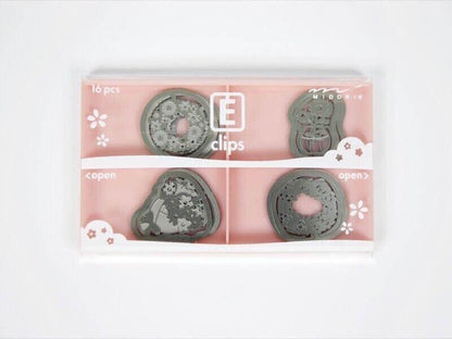 Set of 16 decorative steel E-clips in assorted shapes for paper and office use in a pink box.