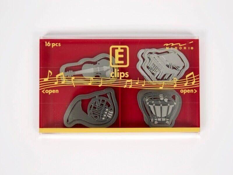 Box of 16 steel paper clips shaped like musical instruments on red background