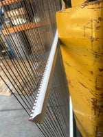Industrial machinery with metal rods and yellow painted panel, warehouse setting