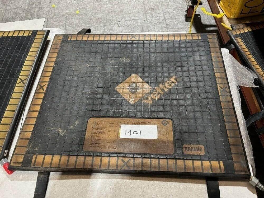 Aramid industrial mat with grid design and label, suitable for heavy-duty use in workshops or warehouses.