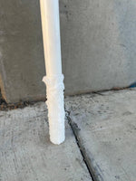 White plastic pipe with textured foam insulation against concrete background