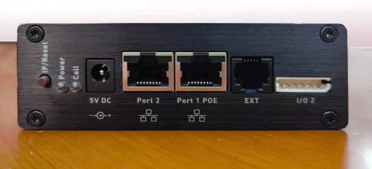 Black office phone system with PoE ports, power input, and I/O connectors for business communication.