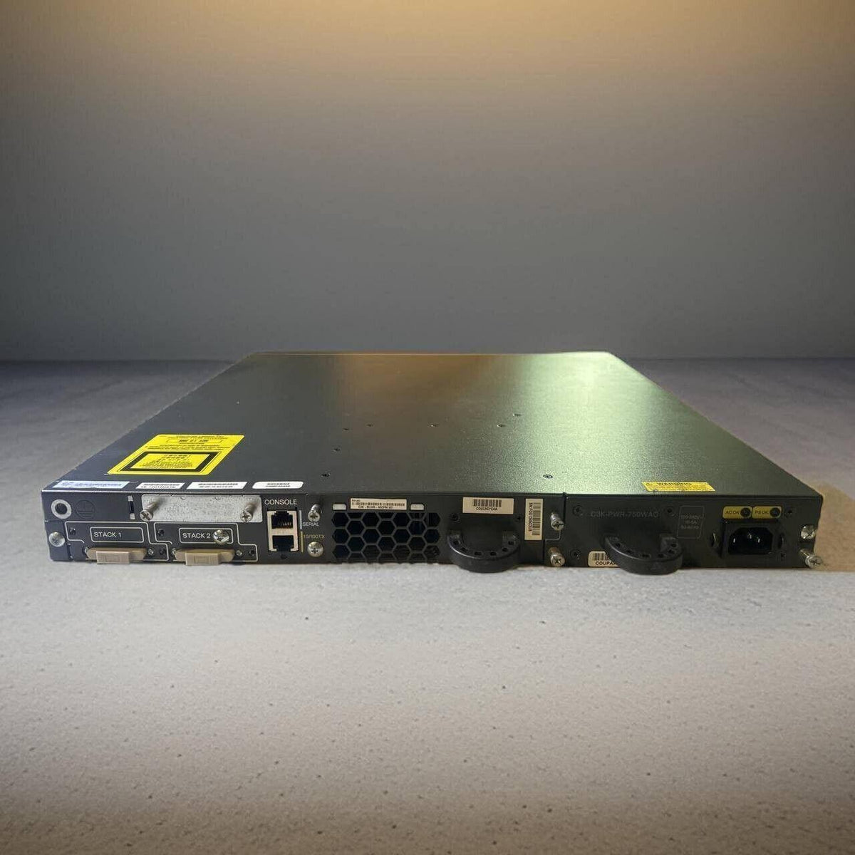 Black network switch with console and stack ports, ideal for office phone systems and IT infrastructure