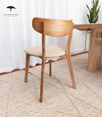 Modern wooden dining chair with beige cushion, paired with matching table, ideal for home or office use