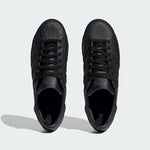 Black Adidas Superstar sneakers with textured design and classic lace-up style